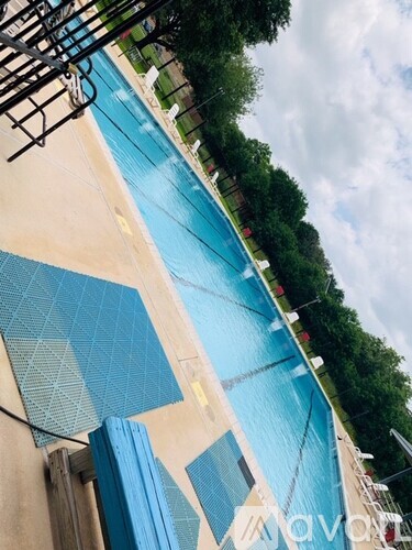 A swimming pool with a blue tiled edge and a metal ladder.