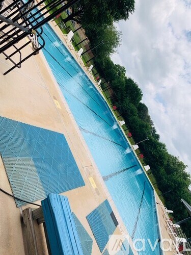 A swimming pool with a blue tiled edge and a metal ladder.
