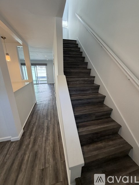 A staircase with wooden steps and a white handrail.