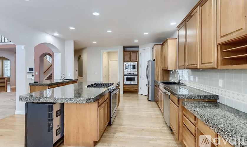 A modern kitchen with wooden cabinets and granite countertops.