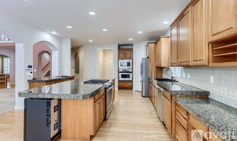 A modern kitchen with wooden cabinets and granite countertops.