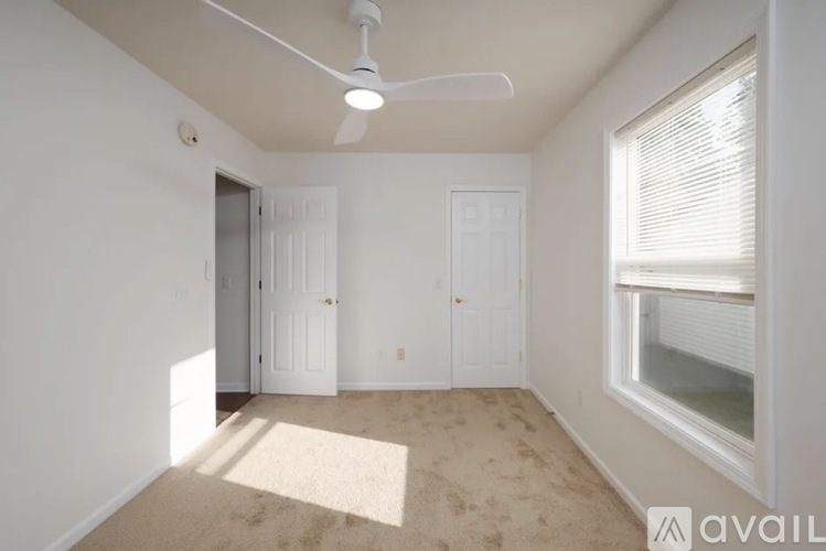 A room with a fan, two doors, and a window.
