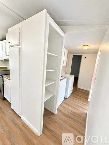 A white kitchen with a white fridge and a white cabinet.