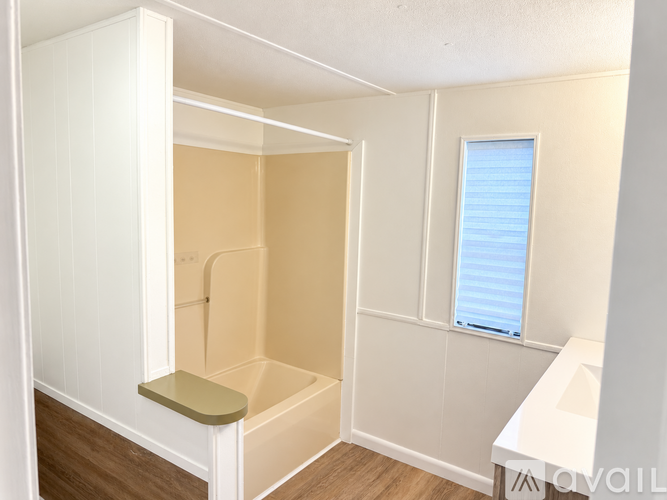 A small bathroom with a shower and a window.