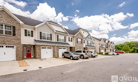 A row of houses with cars parked in front.