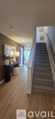 A staircase in a home with a light brown wall and a mirror.