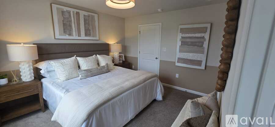 A bedroom with a large bed and a painting on the wall.