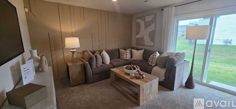 A living room with a grey couch and a wooden coffee table.