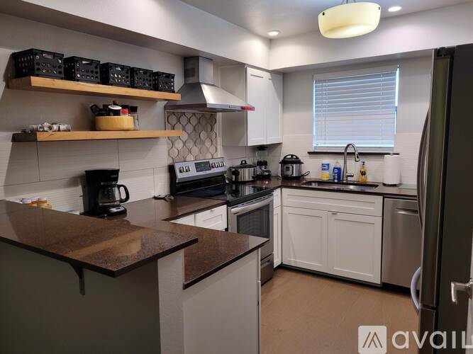 A kitchen with white cabinets and a brown countertop.