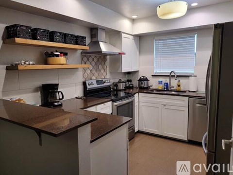 A kitchen with white cabinets and a brown countertop.