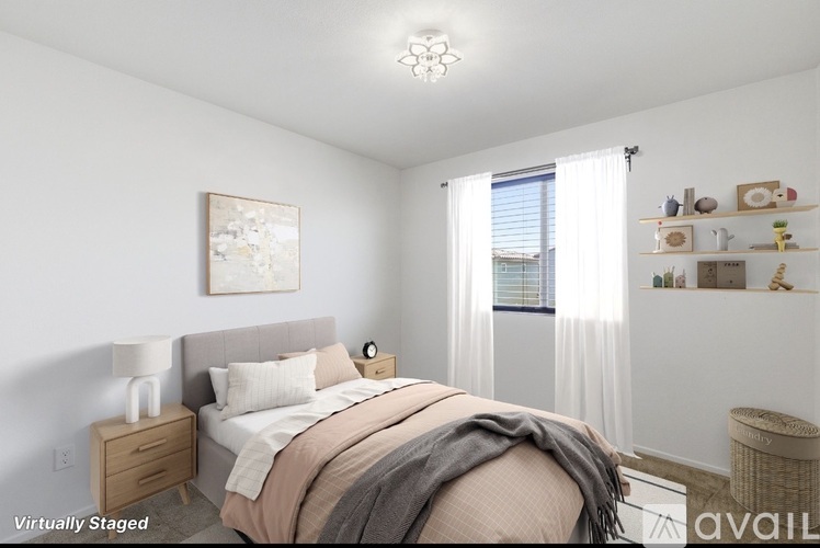 A bedroom with a bed, nightstand, and a painting on the wall.