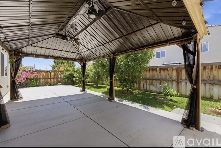 A patio with a metal roof and concrete floor.