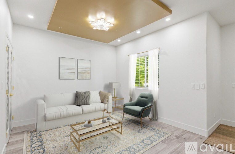 A living room with a white couch, a green armchair, and a gold coffee table.