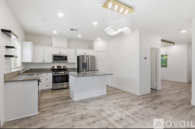A modern kitchen with a granite countertop and stainless steel appliances.