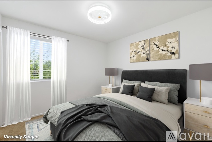 A bedroom with a large bed and a painting on the wall.