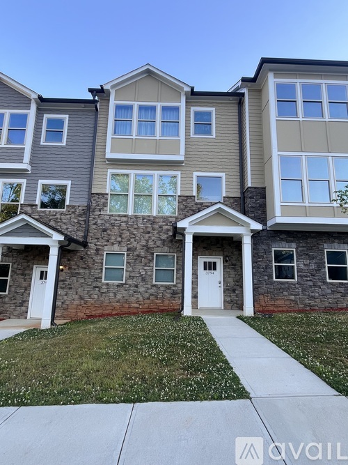 A row of townhouses with a clear blue sky above.