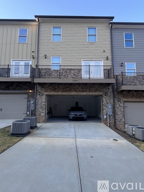 A car is parked in the garage of a two-story apartment building.