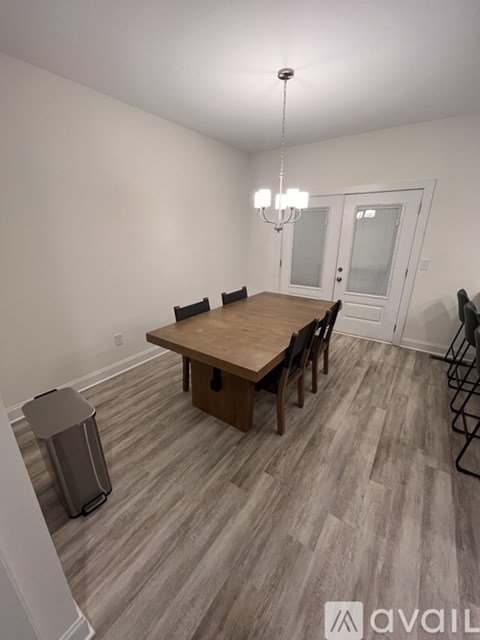 A dining room with a wooden table and chairs.