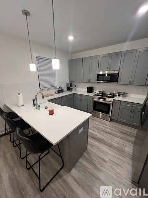 A kitchen with a white countertop and grey cabinets.