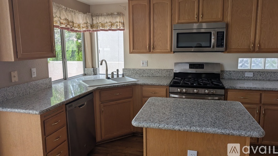 A kitchen with granite countertops and wooden cabinets.