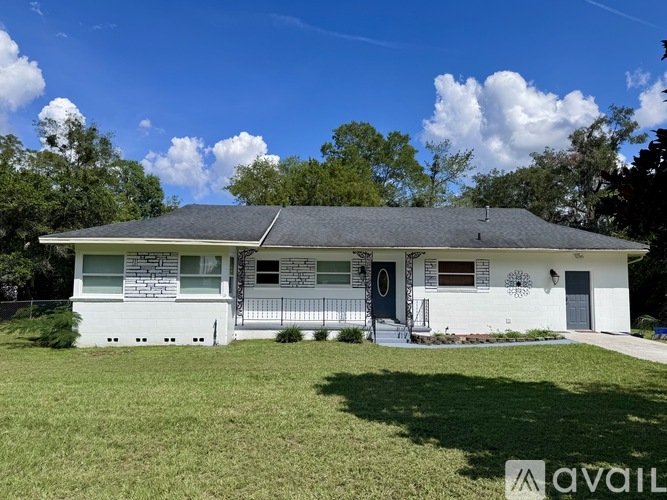 A house with a white front and a grey roof is for sale.