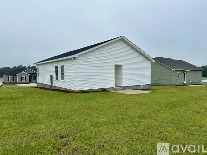 A white house with a grey roof is available for sale.