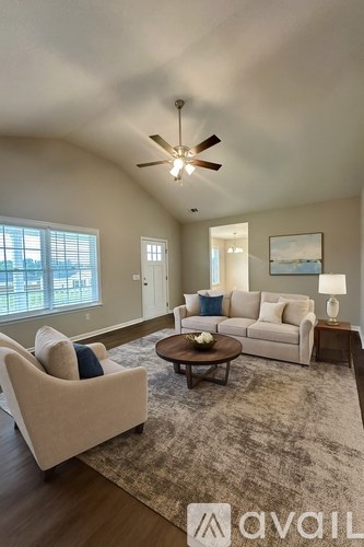 A living room with a beige sofa, a white armchair, and a wooden coffee table.