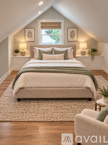 A bedroom with a large bed and a window with a view of trees outside.