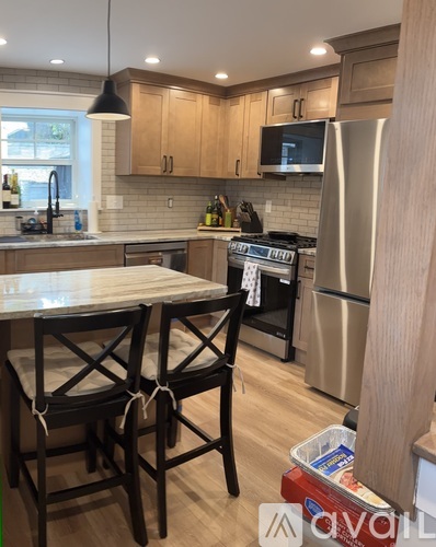 A kitchen with wooden cabinets and a stainless steel refrigerator.