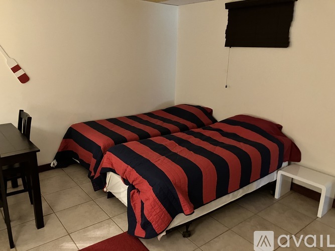 A bedroom with two beds and a desk.