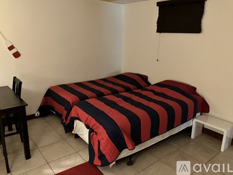 A bedroom with two beds and a desk.