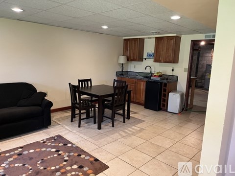 A kitchen area with a table and chairs.