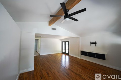 A room with wooden floors and a ceiling fan.