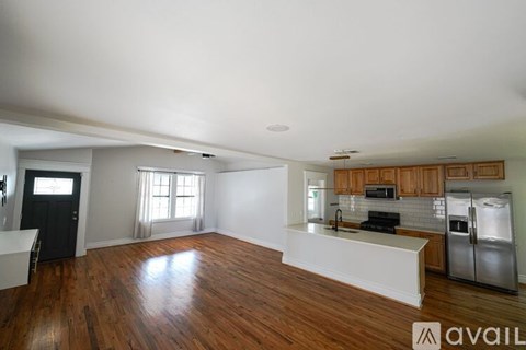 A kitchen with wooden floors and a refrigerator.