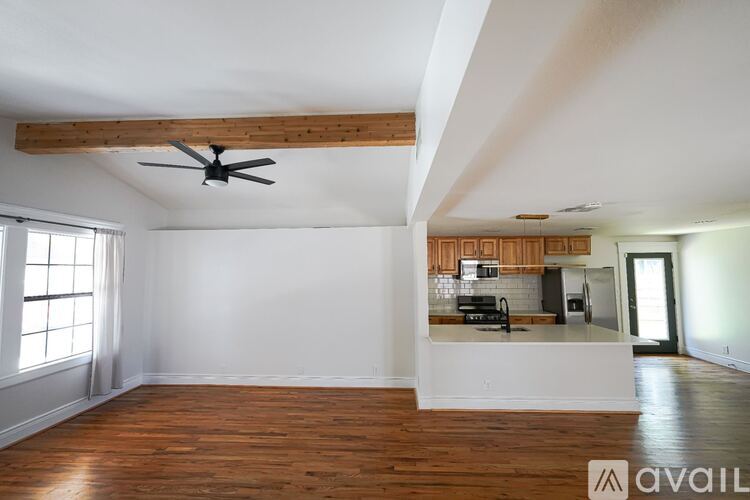 A room with wooden floors and a ceiling fan.