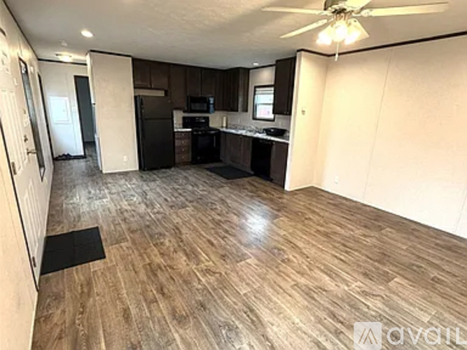 A kitchen with wood flooring and a ceiling fan.