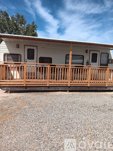 A mobile home with a deck in front.