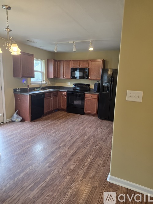 A kitchen with wooden floors and brown cabinets.