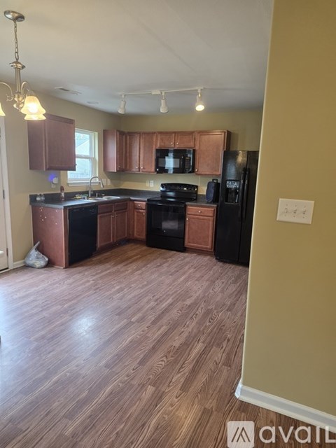 A kitchen with wooden floors and brown cabinets.