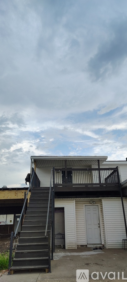 A building with a balcony and stairs leading up to it.