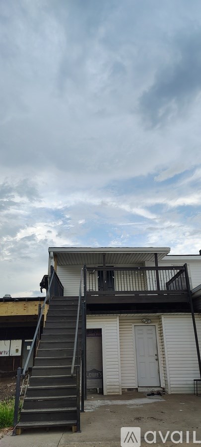 A building with a balcony and stairs leading up to it.