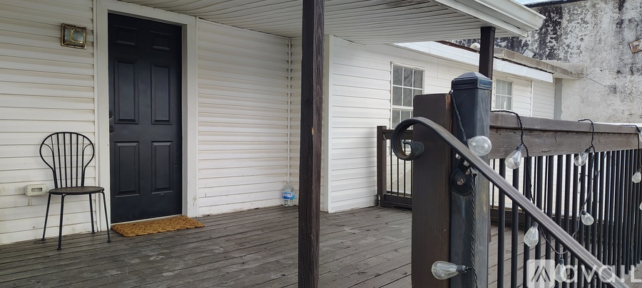 A black door is on the left side of a white house.