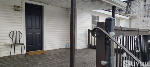 A black door is on the left side of a white house.