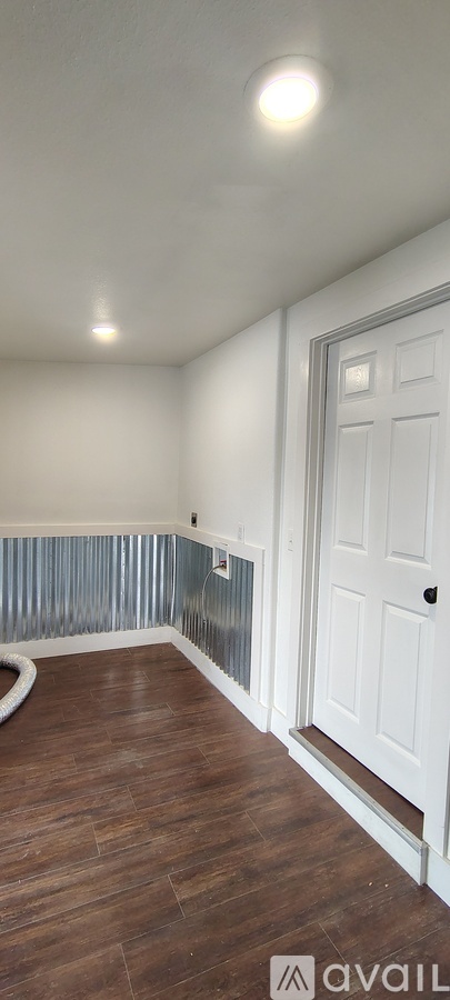 A room with a wooden floor and a white door.