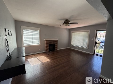 A living room with a fireplace and a ceiling fan.