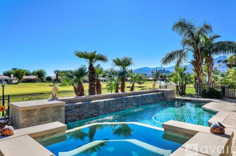 A pool surrounded by palm trees and concrete blocks.