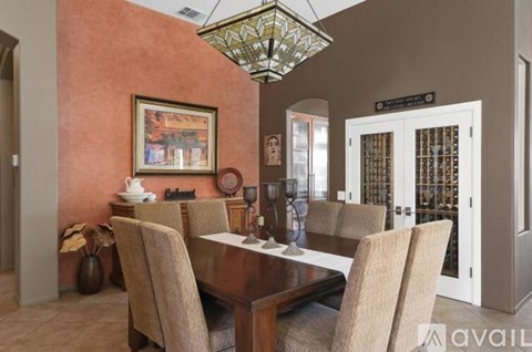 A dining room with a wooden table and chairs.