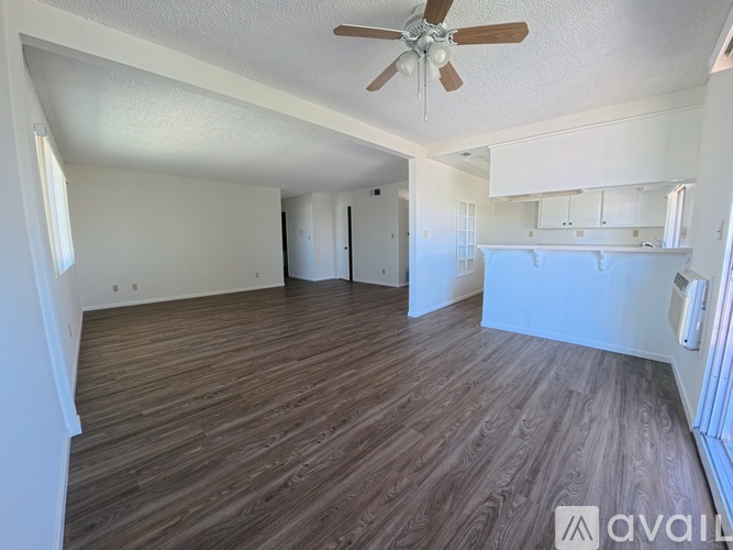 A room with wooden flooring and a ceiling fan.
