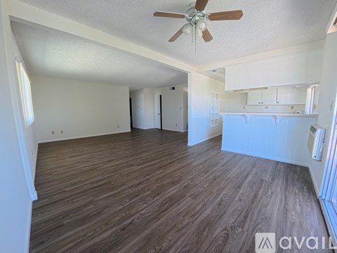 A room with wooden flooring and a ceiling fan.