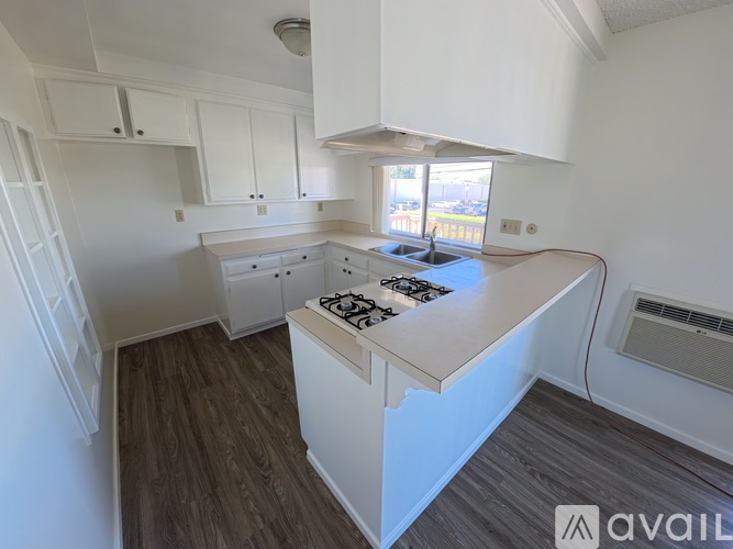 A kitchen with white cabinets and a wooden island.